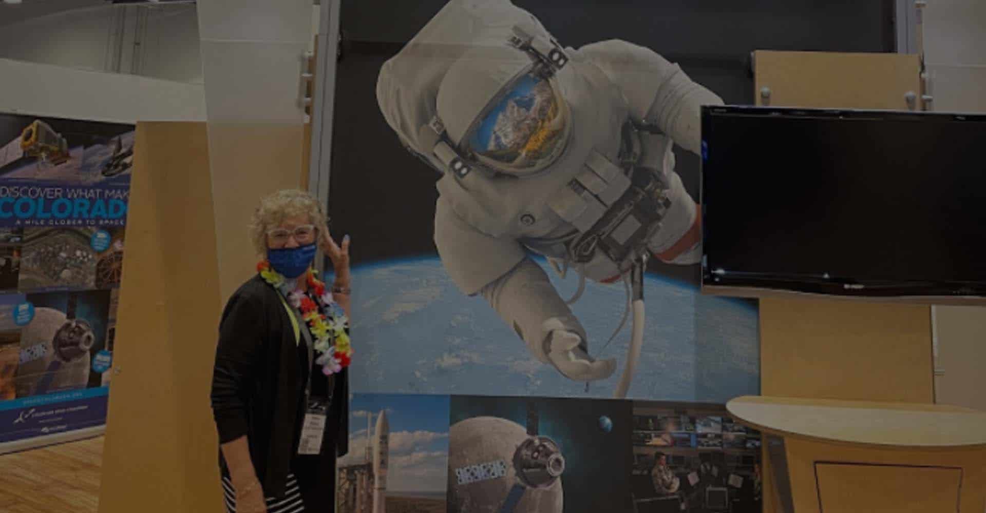 a woman with a booth at the space symposium event